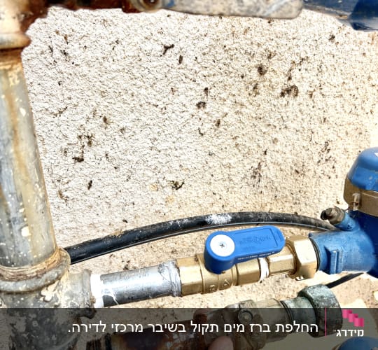 יד מחזיקה צינור חלוד עם ברזים וכלים נוספים